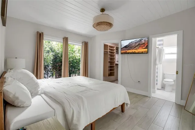 a bedroom with a bed and a large window