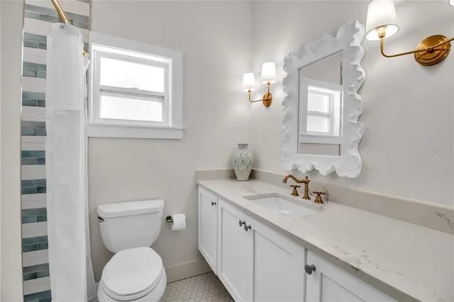 a bathroom with a toilet a sink and mirror