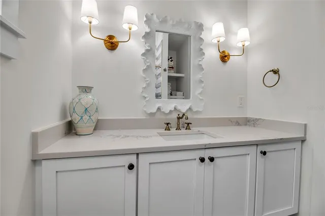 a bathroom with a sink vanity granite and a mirror