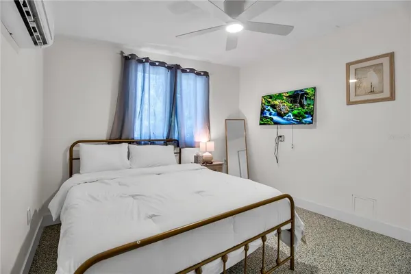 a bedroom with a bed and a flat screen tv