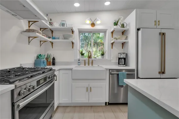 a kitchen with white cabinets and appliances