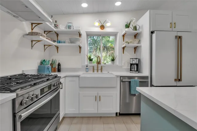 a kitchen with white cabinets and appliances