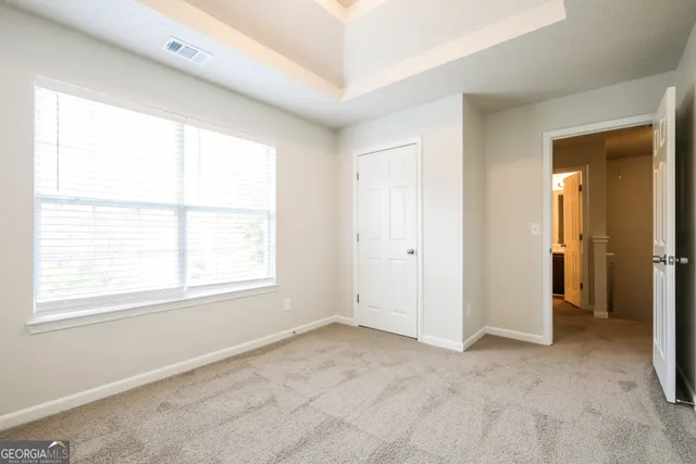 an empty room with windows and closet