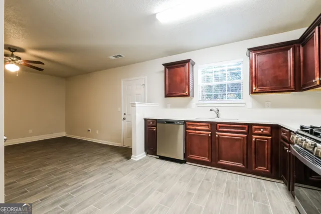 a kitchen with stainless steel appliances granite countertop a stove a sink and a microwave