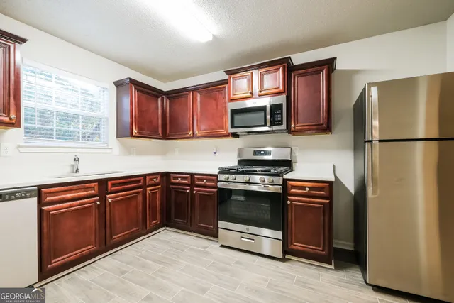 a kitchen with stainless steel appliances granite countertop a refrigerator stove and microwave