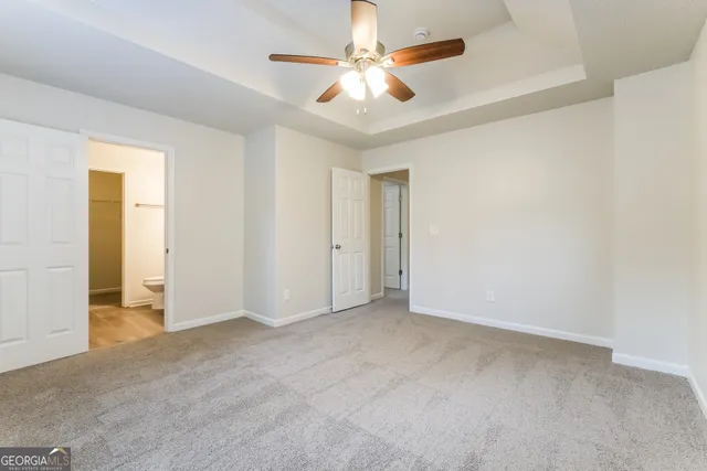 an empty room with closet and a ceiling fan