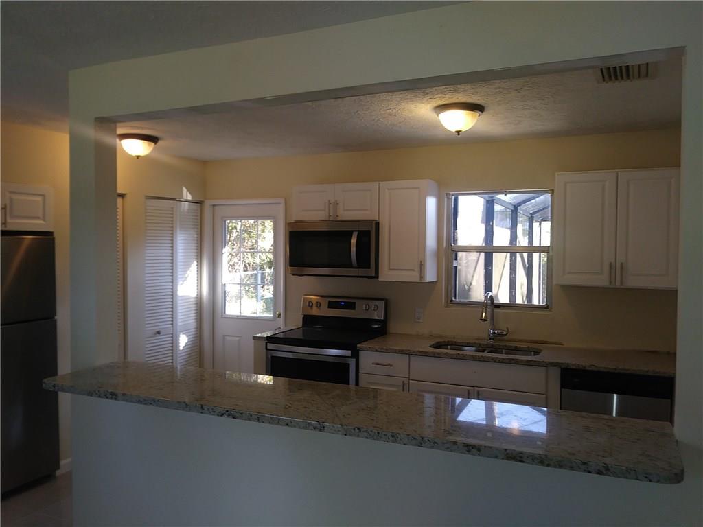 1474 Southwest Del Rio Boulevard Port St. Lucie, FL 34953 - Photo 4 of 9 a kitchen with sink a window and appliances