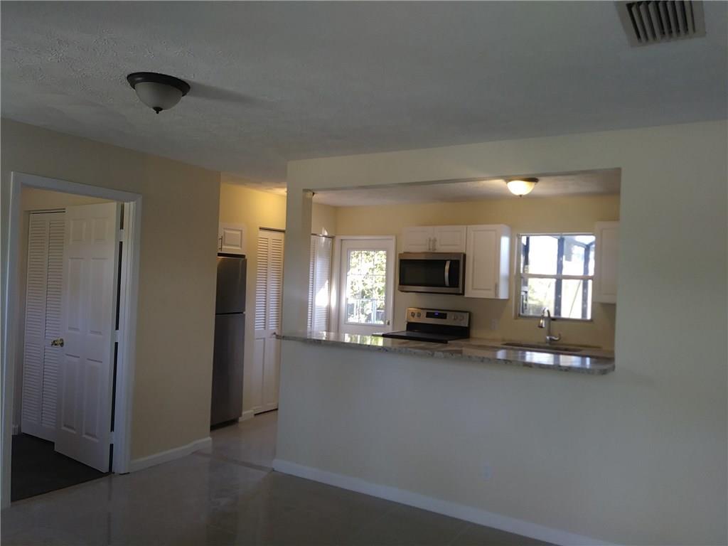 1474 Southwest Del Rio Boulevard Port St. Lucie, FL 34953 - Photo 5 of 9 a view of a kitchen with furniture and a window