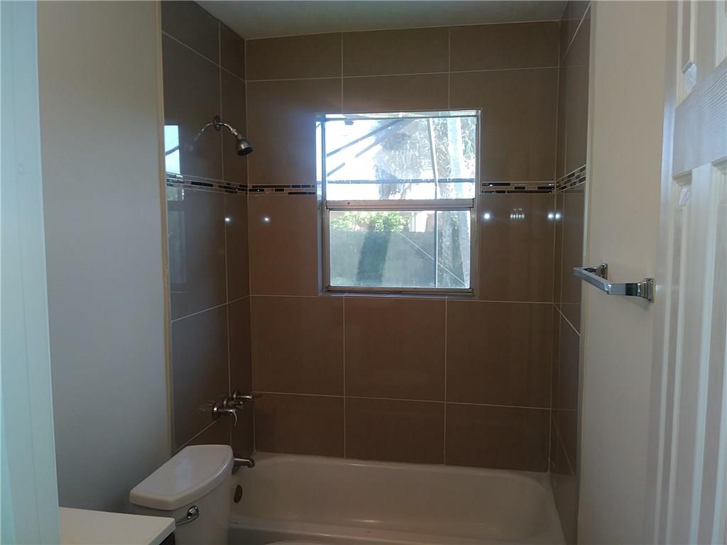 1474 Southwest Del Rio Boulevard Port St. Lucie, FL 34953 - Photo 9 of 9 a bathroom with a window and a shower