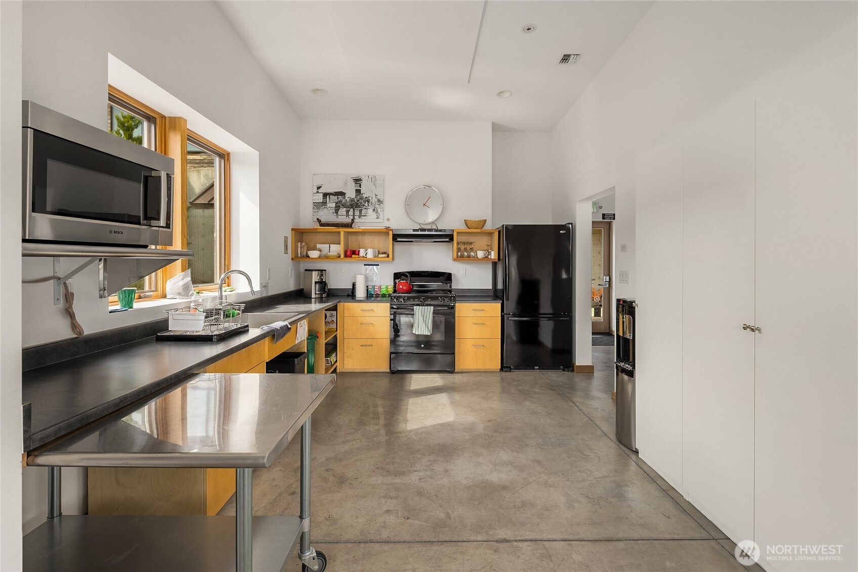 200 Shepard Way Northwest Bainbridge Island, WA 98110 - Photo 22 of 29 a living room with stainless steel appliances furniture a flat screen tv and a kitchen view