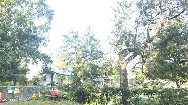 a front view of house with yard and trees around