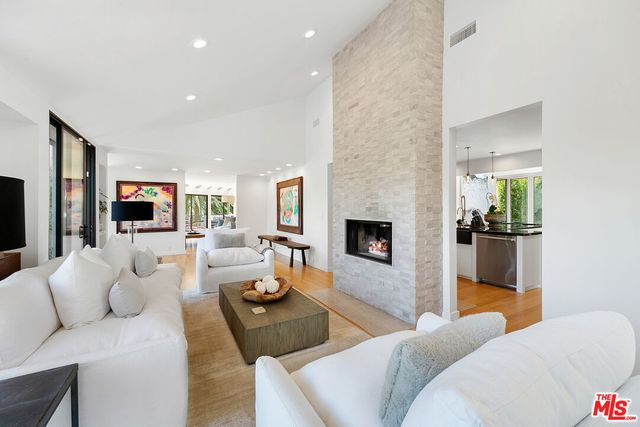 a living room with furniture a large window and wooden floor
