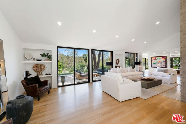 a living room with furniture large window and flat screen tv