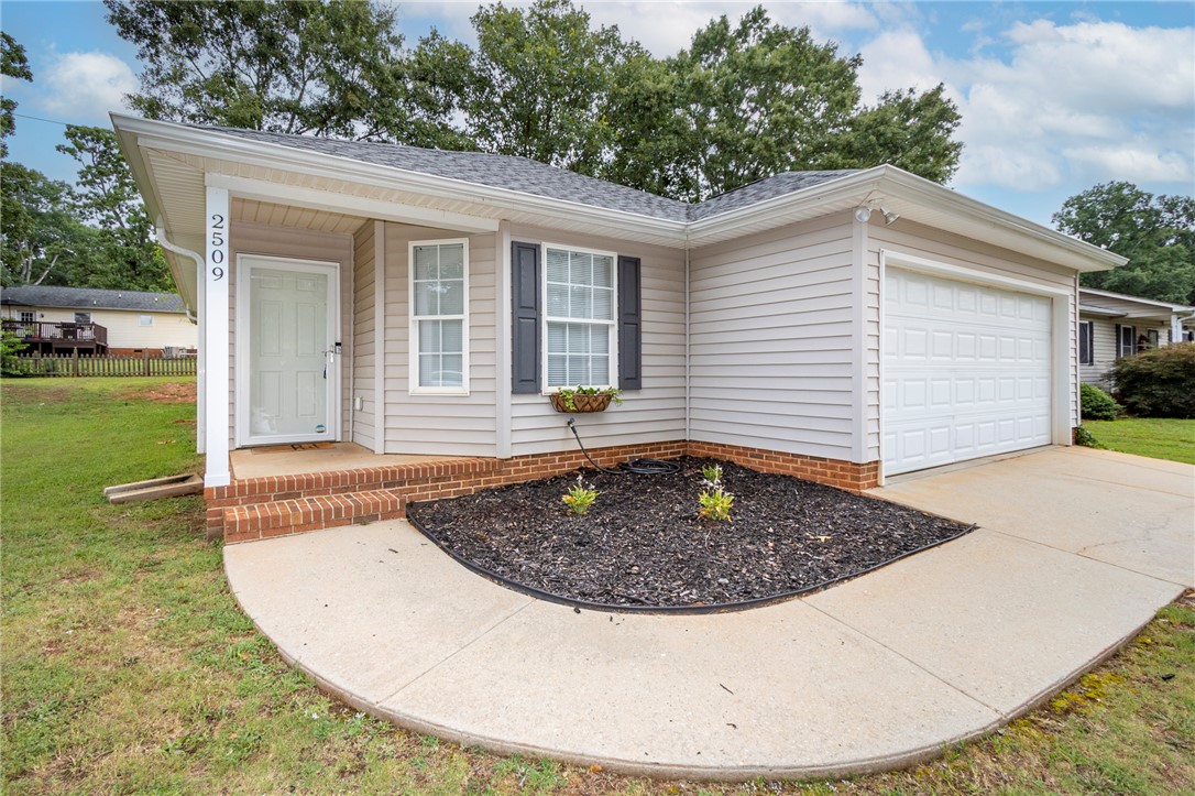 2509 Rolling Green Road Anderson, SC 29621 - Photo 2 of 28 A welcoming facade with a concrete path leading to the inviting front entrance and attached garage.