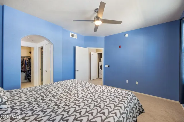 a bedroom with a large bed and a chandelier