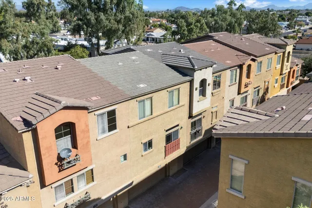 an aerial view of multiple houses with a yard