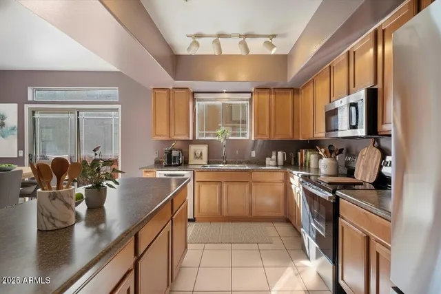 a kitchen with stainless steel appliances granite countertop a sink stove and cabinets