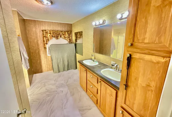 a bathroom with a sink a mirror and a shower