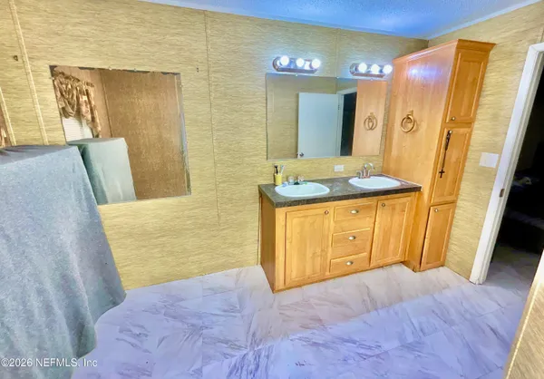 a bathroom with a granite countertop sink a mirror and a shower