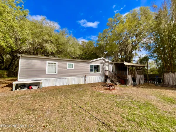 a view of a house with backyard and sitting area