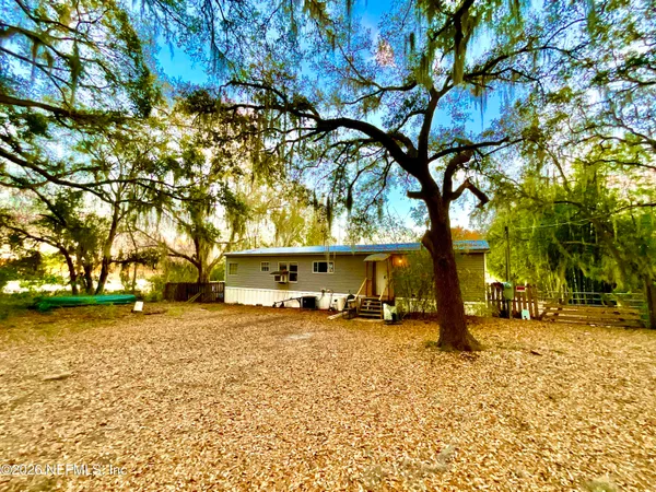 a blue house covered with trees in front of it