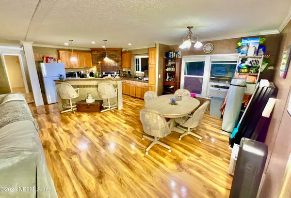a living room with stainless steel appliances kitchen island granite countertop a table and chairs
