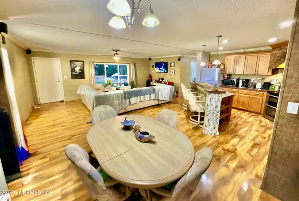 a living room with dining table a table chairs and kitchen view