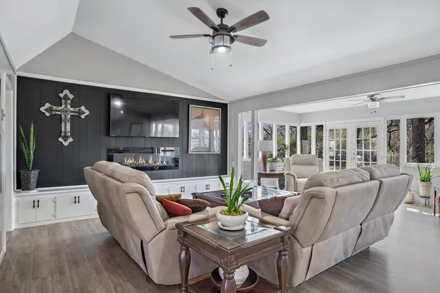 a living room with furniture a ceiling fan and a flat screen tv