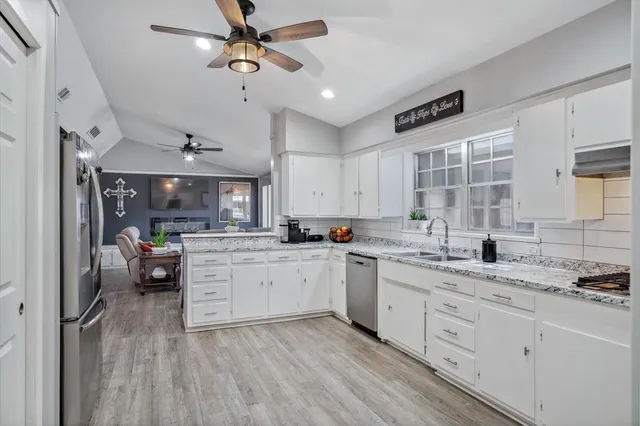 a kitchen with a sink cabinets stainless steel appliances and a window