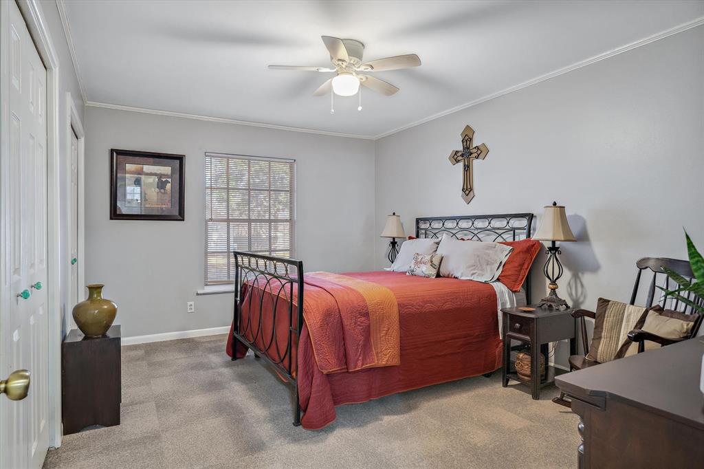 103 Brandon Street Edgewood, TX 75117 - Photo 20 of 29 a bedroom with a bed and a chandelier