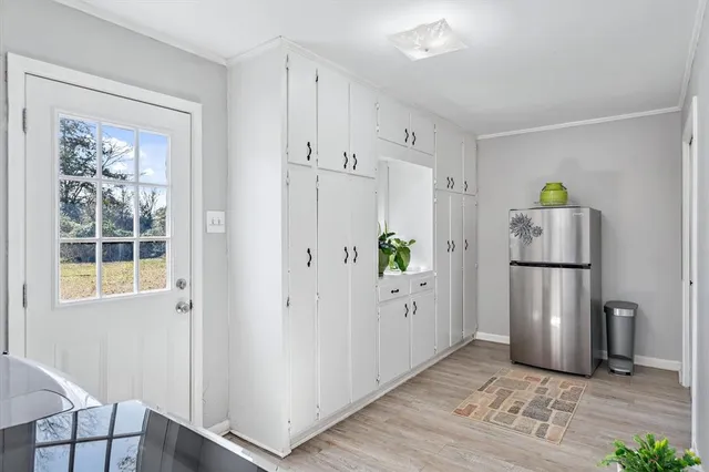 a view of kitchen with a refrigerator cabinets and wooden floor