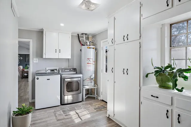 a kitchen with white cabinets stainless steel appliances and wooden floor