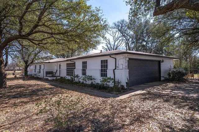 a view of a house with backyard and trees