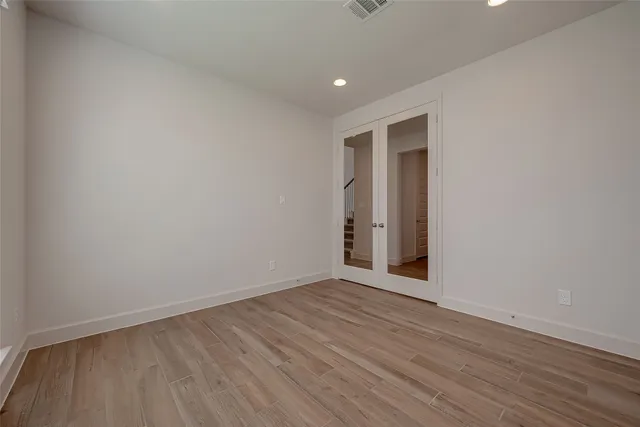 a view of an empty room with wooden floor