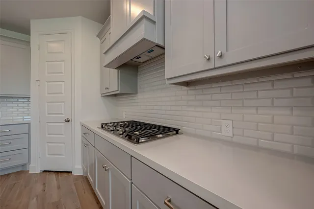 a kitchen with white cabinets and a stove
