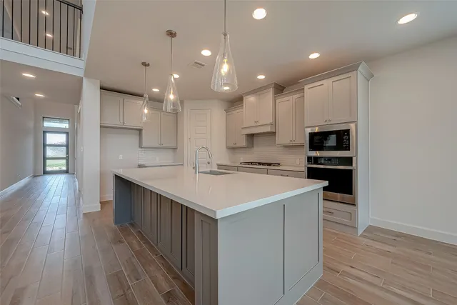 a kitchen with kitchen island a sink and a stove top oven