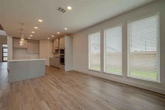a view of kitchen with kitchen island wooden floor center island and stainless steel appliances