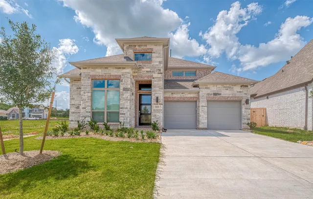 a view of a house with a big yard and large tree
