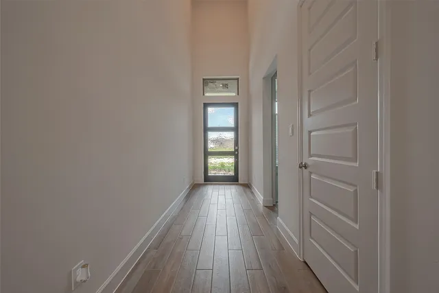 a view of hallway with a large window and wooden floor