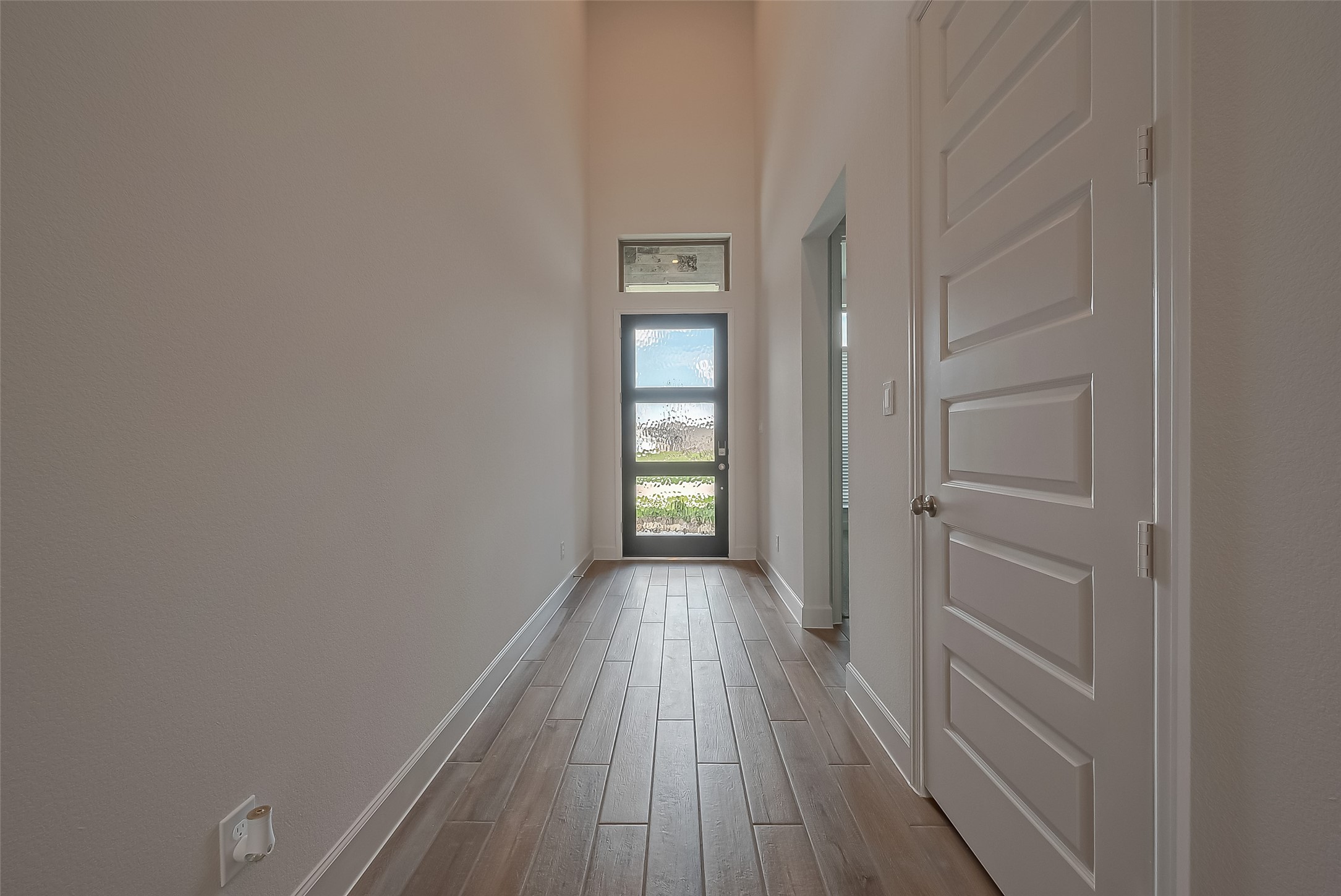 30223 GOLD FINCH Place Fulshear, TX 77441 - Photo 4 of 45 a view of hallway with a large window and wooden floor