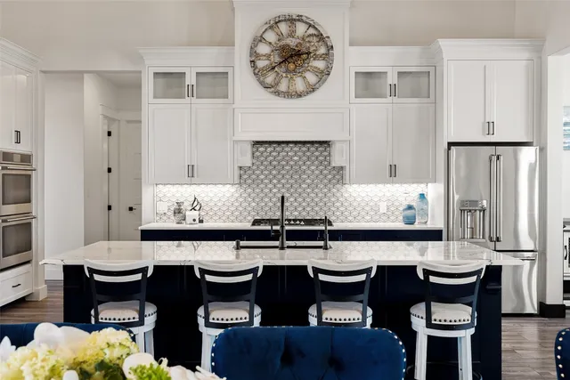 a kitchen with granite countertop a table chairs stove and cabinets