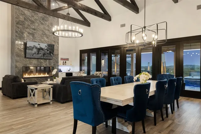 a view of a dining room with furniture a chandelier and wooden floor