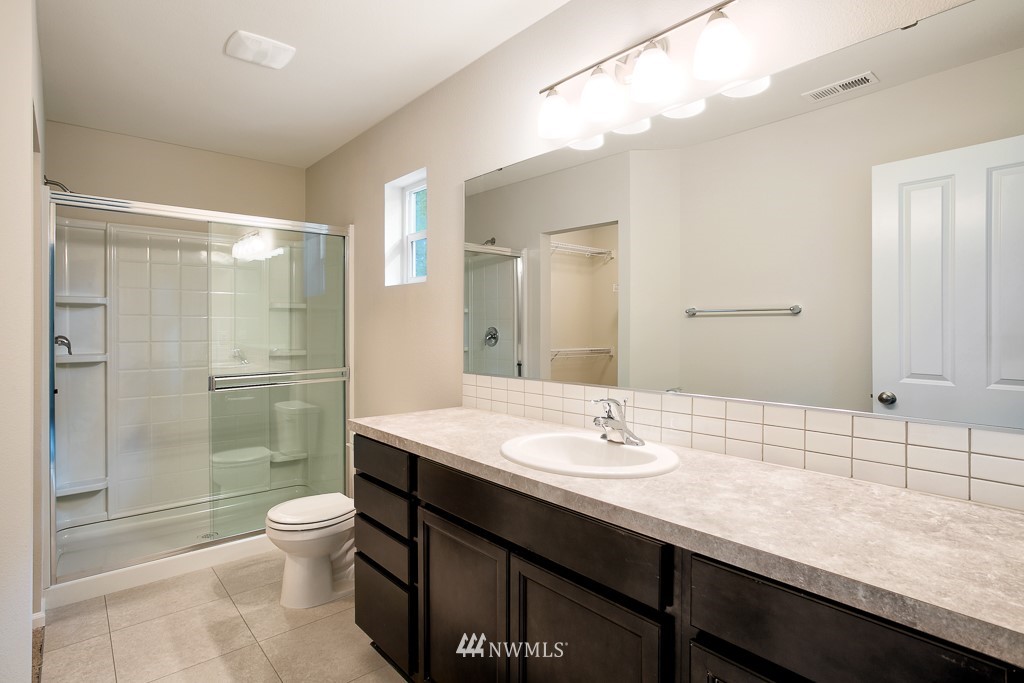 207 169th Place Southwest Bothell, WA 98012 - Photo 12 of 21 a bathroom with a granite countertop sink a toilet a mirror and shower