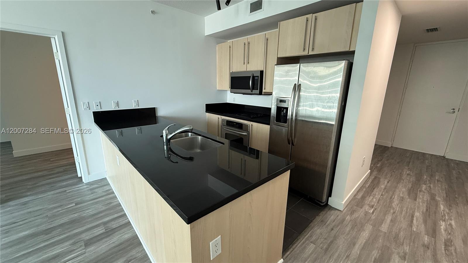 79 Southwest 12th Street, Unit 2509S Miami, FL 33130 - Photo 1 of 27 a kitchen with stainless steel appliances granite countertop a refrigerator a stove and a wooden floors