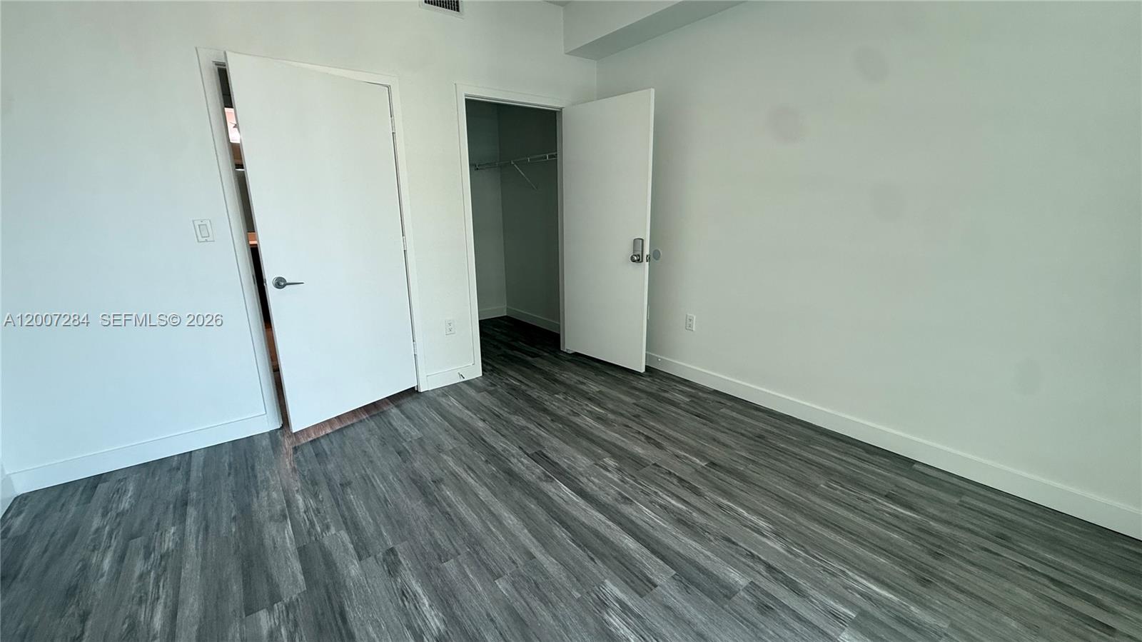 79 Southwest 12th Street, Unit 2509S Miami, FL 33130 - Photo 12 of 27 a view of an empty room with wooden floor and a window