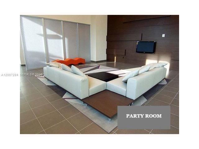 79 Southwest 12th Street, Unit 2509S Miami, FL 33130 - Photo 22 of 27 a living room with a couch and a flat screen tv