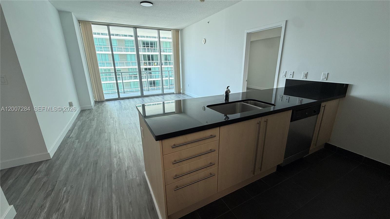 79 Southwest 12th Street, Unit 2509S Miami, FL 33130 - Photo 3 of 27 a kitchen with a sink and wooden floor