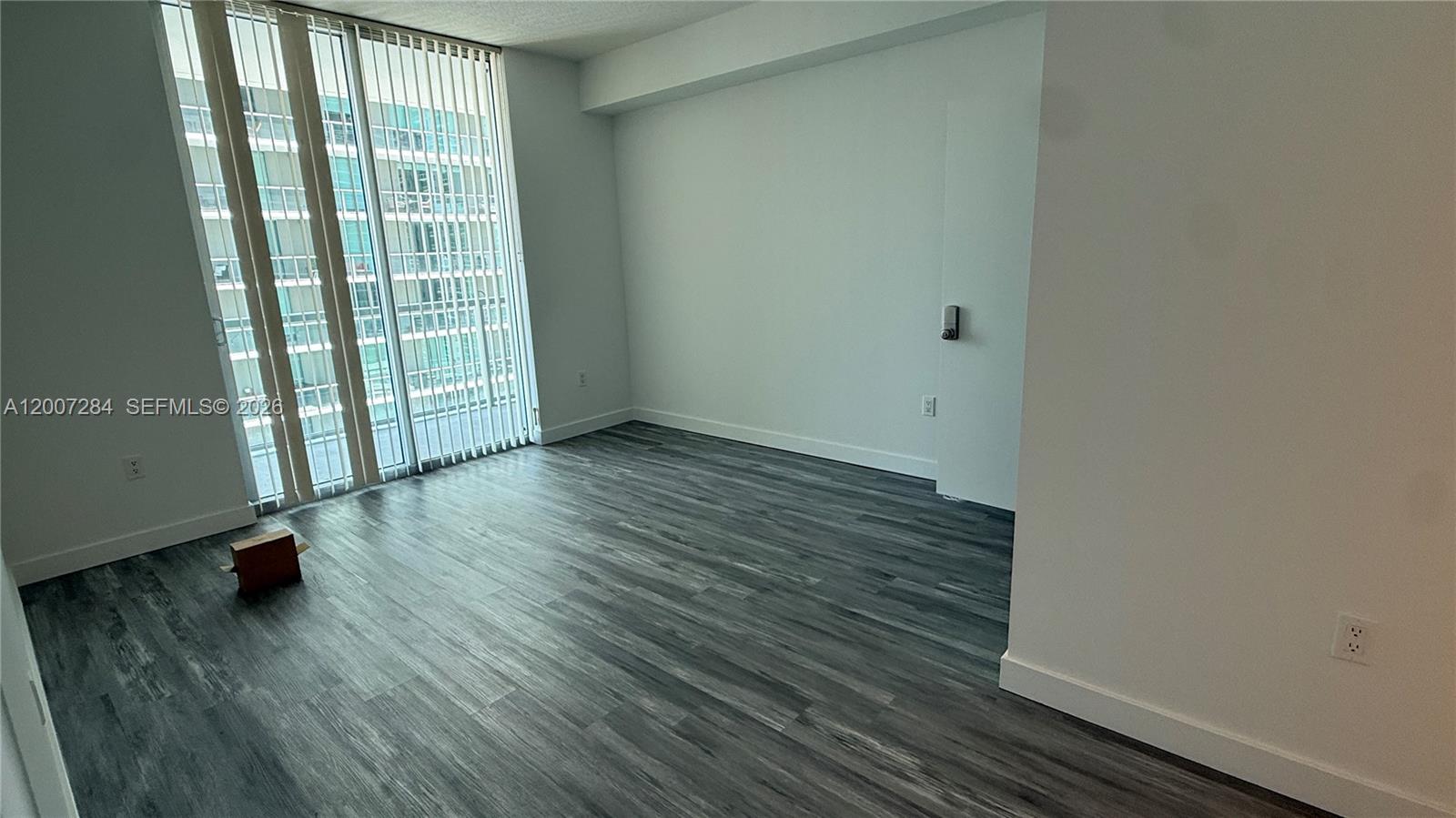 79 Southwest 12th Street, Unit 2509S Miami, FL 33130 - Photo 7 of 27 an empty room with wooden floor and windows