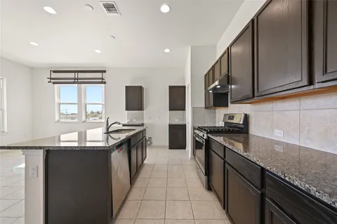 a large kitchen with kitchen island a sink a stove a refrigerator and a cabinets