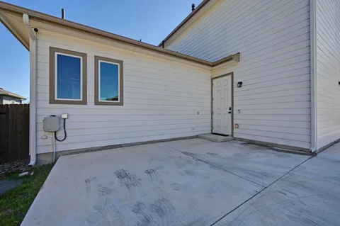 an empty room with windows and ceiling fan